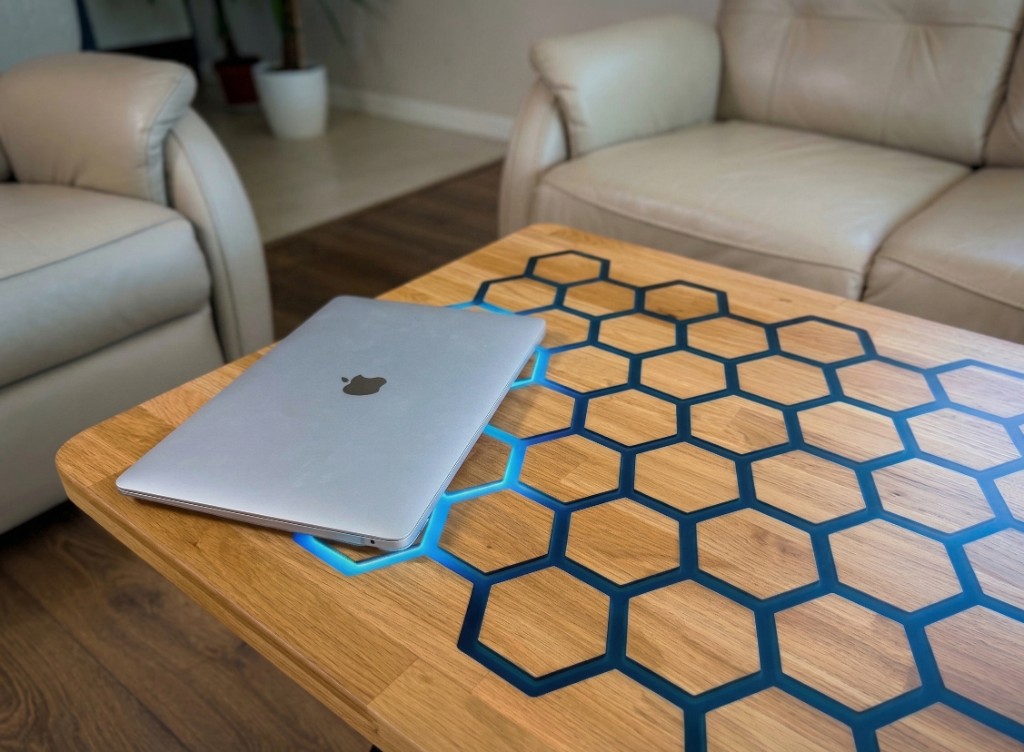 Stół Vuxo w salonie z laptopem i podświetlonym wzorem plastra miodu