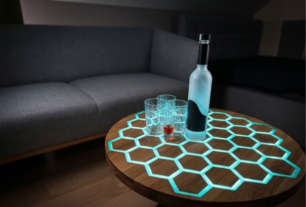 Okrągły stół Vuxo z podświetlonym blatem w wzór plastra miodu w salonie